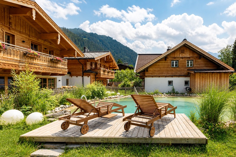 Birnbaum Chalets Großarl mit Naturbadeteich, Holzterrasse und alpinen Chalets im Salzburger Land