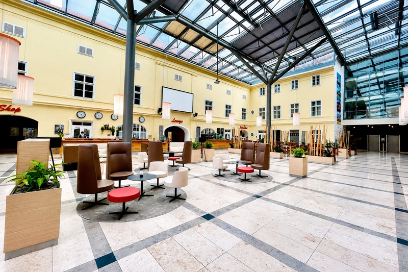 Lobby und Atrium des JUFA Hotel Wien City in Wien-Simmering mit Sitzbereichen und Glasdach