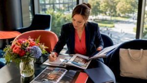 Die Hotelleiterin informiert sich im Büro in aktuellen Fachzeitschriften über Branchentrends.