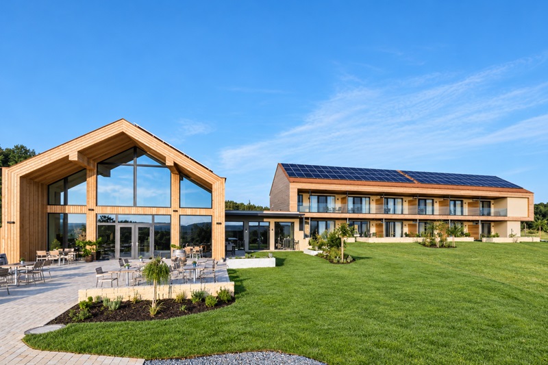 JUFA Hotel Neutal im Burgenland mit Holzfassade, Terrasse und grüner Gartenanlage